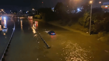 Vehicles Drive Through Flooded Highway in Lansing