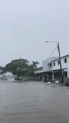 Car Drives Along Flooded Main Street