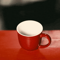 Video gif. A carafe pours coffee into a red mug, which immediately begins to disappear slowly.