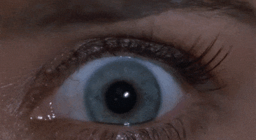 Movie gif. A close up on Tea Leoni as Julie Mott’s eye in Bad Boys. Her pupil suddenly shrinks out of shock. 