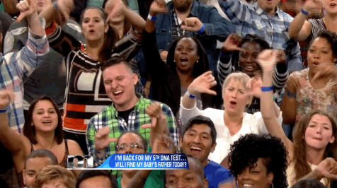 Reality TV gif. The audience from Maury are all on their feet and they're booing with glee.