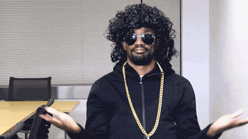 Video gif. Man with long curly black hair wearing sunglasses gives us a shrug like he's saying, "What?"