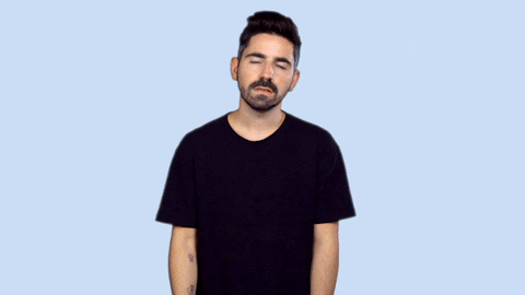 Video gif. A man in a black tee shirt facepalms and shakes his head in disappointed disbelief. 