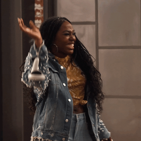 TV gif. Laci Mosley as Harper in iCarly smiles brightly as she dances with a hip shake and a palm raised in the air. 