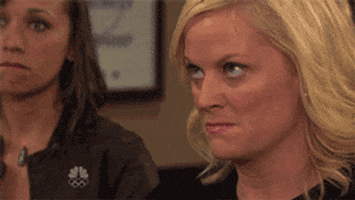 Parks and Recreation gif. Amy Poehler as Leslie purses her lips as her eyes dart around, in a seething rage.