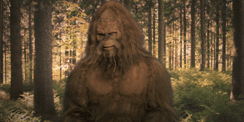 Ad gif. In a Jack Link's Jerky advertisement, standing in a forest, Bigfoot blows us a kiss with his hairy hand before giving us a flirty wave.