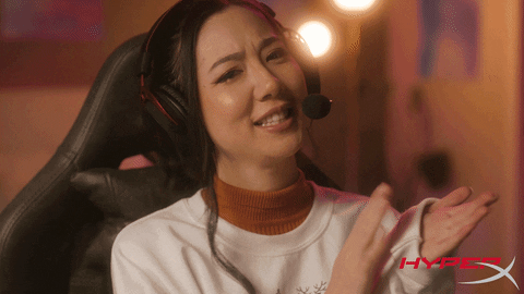 Video gif. A woman wears gaming headphones as she golf claps and gives two thumbs up. 