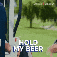 Sponsored gif. Person holding two tall cans of Michelob Ultra beer hands one of the cans to another person. Text reads, “Hold my beer.”