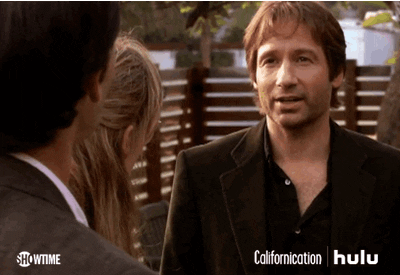 TV gif. David Duchovny as Hank in Californication crosses his fingers and says, “Fingers crossed.”