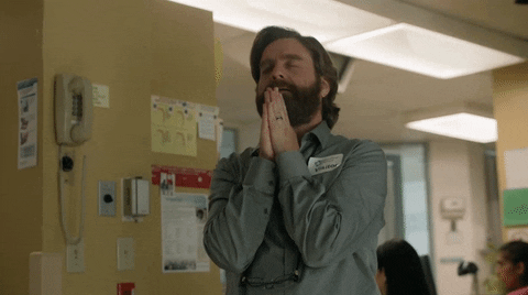 TV gif. Zach Galifianakis as Dale in Baskets. He's standing in a hospital and he has his hands in the prayer position with his eyes closed. He presses his hands tightly together and moves his hands outwards twice.
