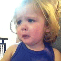 Video gif. A close up shot of a toddler making an extremely sad face and pouting, while tears fill their eyes. They are incredibly sad.