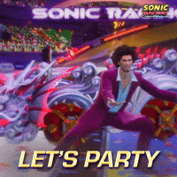 Sponsored gif. Man in a purple suit gestures for a group of spectators to get louder before a round of Sonic the Hedgehog racing. An elaborate race car sits behind him. Text reads, “Let’s party.”
