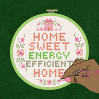 Text gif. Hand stitching a classic needlepoint with a little house and the message "Home sweet energy efficient home" against a lush green background.