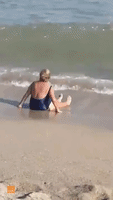 Beachgoer Struggles To Stand Up in Shallow Water