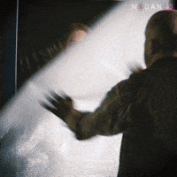 Sponsored gif. Haunted doll Megan escapes from her box and tackles a man to the ground.