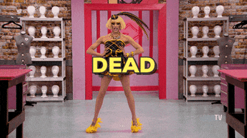 Reality TV gif. A contestant from RuPaul's Drag Race poses for the judges before hitting a dip, a dance move from voguing. They fall backwards on the floor and lay flat with one knee bent, and the text reads, "Dead." 