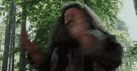 Movie gif. Robbie Coltrane as Hagrid in Harry Potter looks around and claps.