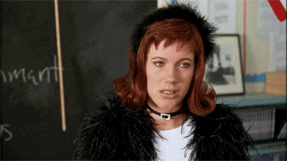 Movie gif. Elisa Donovan as Amber from Clueless makes a W with her hands as she mouths the word, whatever.