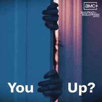Sponsored gif. Person clutches the side of a door and slowly creeps around the edge of it. Text reads, “You up?” In the upper right corner is the logo for AMC's Halfway to Halloween Month, streaming on Shudder.