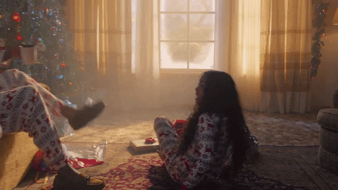 Music video gif. A scene from Taylor Swift's Lover music video. A family dressed in matching christmas pajamas all hug each other on christmas morning. 