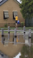 Man Walks on Stilts Through Victoria Flood Waters