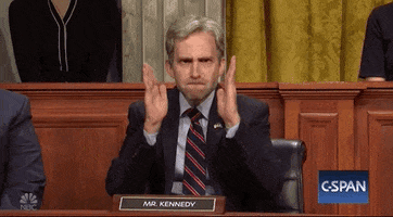 SNL gif. Kyle Mooney as Louisiana Sen. John Kennedy sits in Congress, his name plate displayed in front of him. He gestures down with his hands parallel in front of him, as if to show how long something is, with his face contorted into a serious grimace. 
