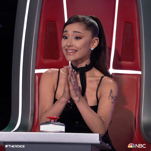 Celebrity gif. Ariana Grande claps presto, hands close beneath her chin, with a restrained but genuine smile, expressing enthusiasm with prim vim.
