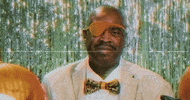 Celebrity gif. Slick Rick looks at us, smiling, and holding his hand in the “Okay” symbol.