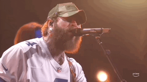 ACM Awards gif. Post Malone sings into microphone briefly twitching head from side to side. 