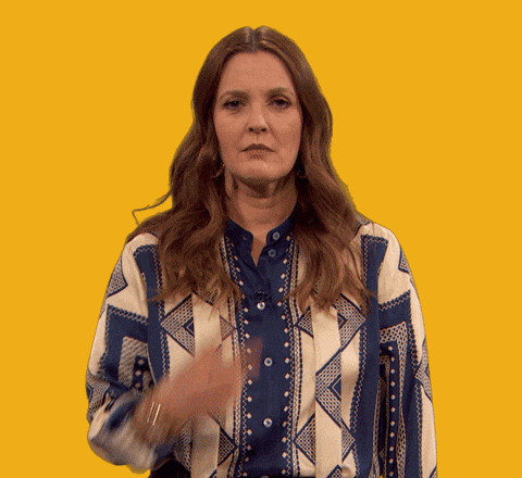 Celebrity gif. Drew Barrymore stares at us with a serious expression. She points two fingers at her eyes and then points them to us, threatening that she's always watching us. 