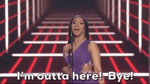 Celebrity gif. Cardi B at the 2019 Billboard Music Awards smiles as she says into the mic, "I'm outta here! Bye!" and then turns around to walk off.
