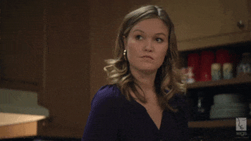 TV gif. Julia Stiles as Blue in Blue raises her eyebrows and gestures with her hand as if to say, "After you."