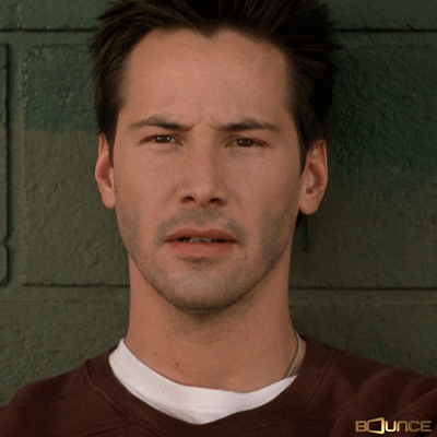 Celebrity gif. Keanu Reeves leans against a brick wall. He furrows his eyebrows, tilts his head, and blinks in utter confusion.