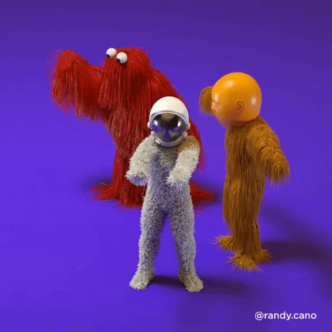 Video gif. Three people if furry costumes with googly eyes and helmets dance awkwardly. One wears a furry white suit with an astronaut helmet, another wears long orange fur with an face helmet, and the last wears long red fur with googly eyes.