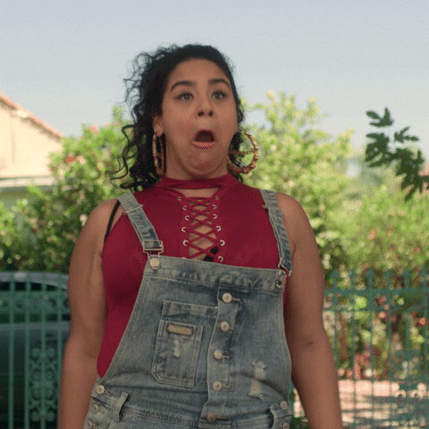 TV gif. Jessica Marie Garcia as Jasmine in On My Block turns and claps excitedly with her mouth is open as if cheering. 