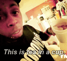 Celebrity gif. Lil Wayne holds a cup of iced tea and gives a wide grin. Text, "This is tea in a cup."