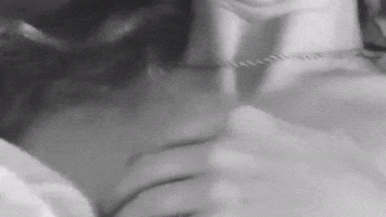 Music video gif. From Fletcher's video for Sex with my Ex, choppy black and white footage of a woman looking at us while adjusting herself onto a pillow.