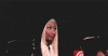 Celebrity gif. We zoom in on Nicki Minaj as she purses her lips and flutters her lashes with a side eye.