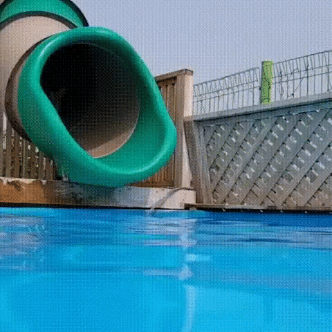 Video gif. A brown and white corgi comes flying out of a pool slide as it bounds cheerfully into the water below. 