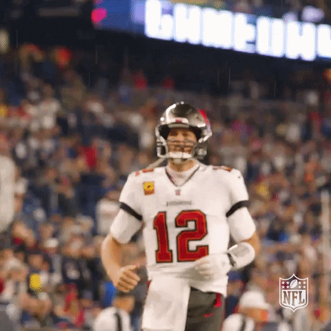 Sports gif. Tom Brady of the Tampa Bay Buccaneers pumps his fist in the air and yells, ecstatic.