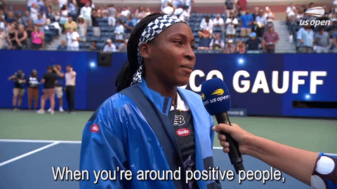 Sports gif. Tennis player Coco Gauff is being interviewed after a match. Shrugging her shoulder with a calm and pleasant demeanor as she says, "When you're around positive people you can't be negative for too long."