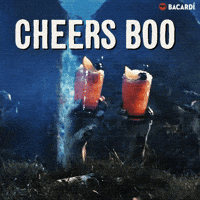 Sponsored gif. Two zombie hands reaching up out of the ground in a graveyard, toasting with orange cocktails. The Bacardi logo is in the upper right hand corner. Text:"CHEERS BOO"