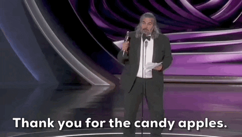 Oscars 2024 gif. Hoyte van Hoyteme wins Cinematography for Oppenheimer. He pumps out his arm while holding the Oscars trophy. He says, "Thank you for the candy apples" before turning around and quickly glancing back with an amused smile. 