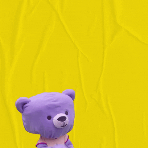 Digital art gif. A stuffed purple teddy bear pops up and kisses its paw. A big white heart appears and the text, “Muah!” after it sends out its kiss.