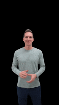 Video gif. A man in a gray long sleeve shirt and dark blue sweatpants stands in front of a black background. He clasps his hands together and shakes them towards the sky on each side with a smile on his face. 