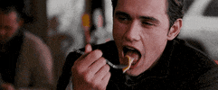 Celebrity gif. James Franco as Harry in Spider-Man 3 taking a bite of something, smiling, and saying "so good."