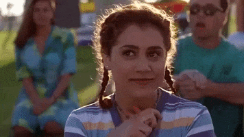 Movie gif. Brittany Murphy as Tai in Clueless, her hair in two pigtail braids, clasps her hands to her chest and sighs deeply, a longing expression on her face as she smiles.