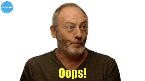 Celebrity gif. Liam Cunningham puts his finger to his lips coyly. Text, "oops."