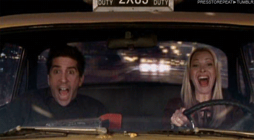 Friends gif. An elated Lisa Kudrow as Phoebe drives a taxi while David Schwimmer as Ross looks terrified in the passenger seat.