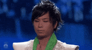 Reality TV gif. A contestant on America's Got Talent looks nervous as he puts his hands in a prayer position and rests his head between his fingers.